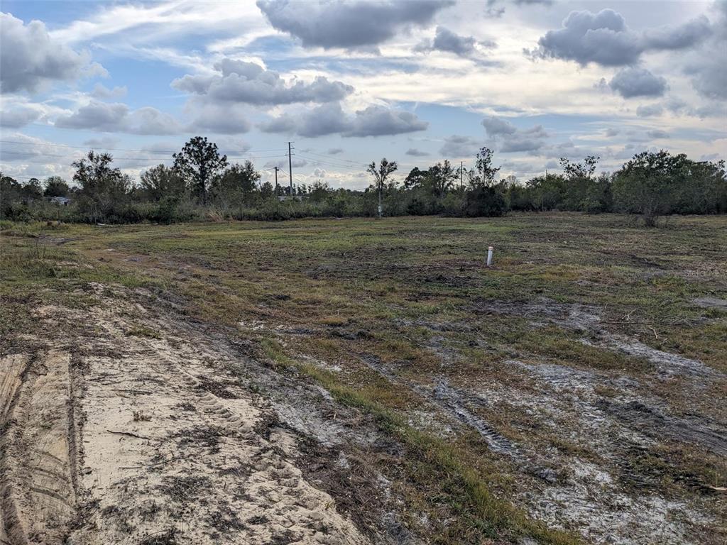 A flat, cleared, grassy lot with tire tracks and a single white utility pipe — 4830 HOLOPAW STREET, LAKE WALES, FL