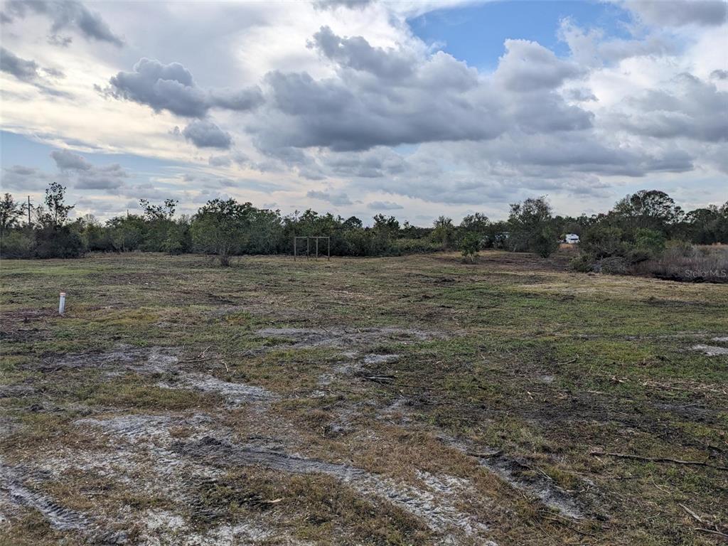 A large, cleared, and uneven grassy lot under a cloudy sky — 4830 HOLOPAW STREET, LAKE WALES, FL