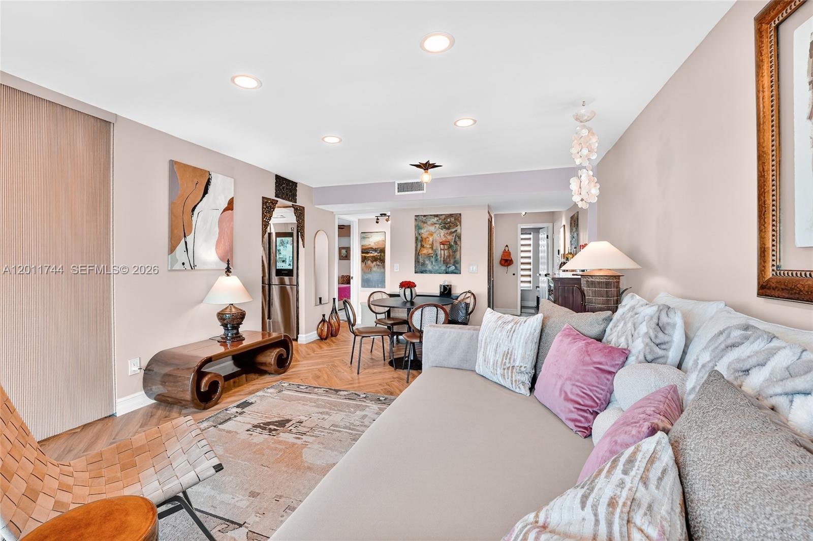 A living room with a sofa, dining area, and wood-patterned flooring — 1455 West Ave # 501, Miami Beach FL 33139, MIAMI BEACH, FL
