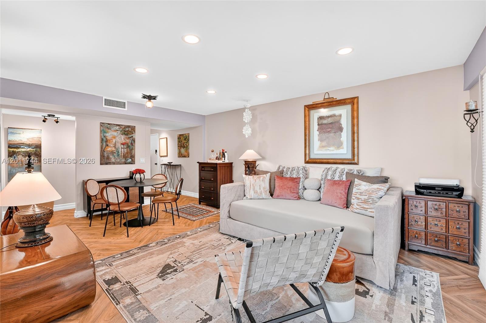 A living room with a sofa, dining area, and herringbone wood flooring — 1455 West Ave # 501, Miami Beach FL 33139, MIAMI BEACH, FL