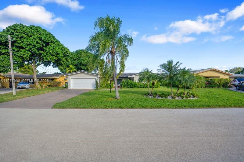 A single-story house with a white garage and palm trees sits behind a green lawn — 1810 SW 6th Ave, Pompano Beach FL 33060, POMPANO BEACH, FL