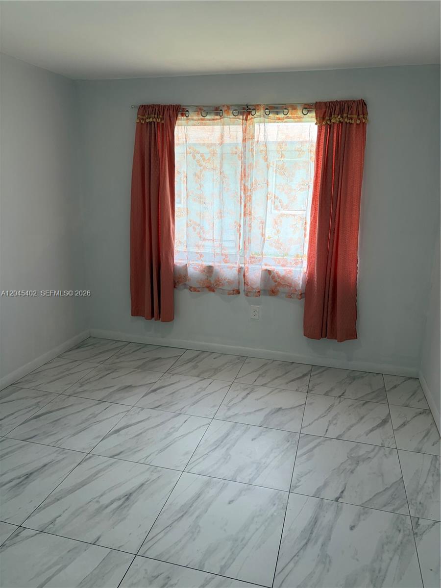 A room with light blue walls, white marble-patterned tile flooring, and coral-colored curtains — 14399 NE 5th Pl # 5, North Miami FL 33161, NORTH MIAMI, FL
