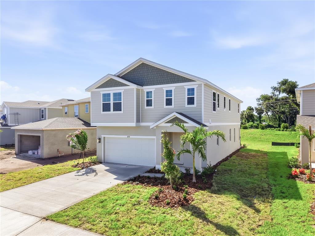 A two-story suburban house with light gray siding, a garage, and a concrete driveway — 2513 29TH LANE E, PALMETTO, FL