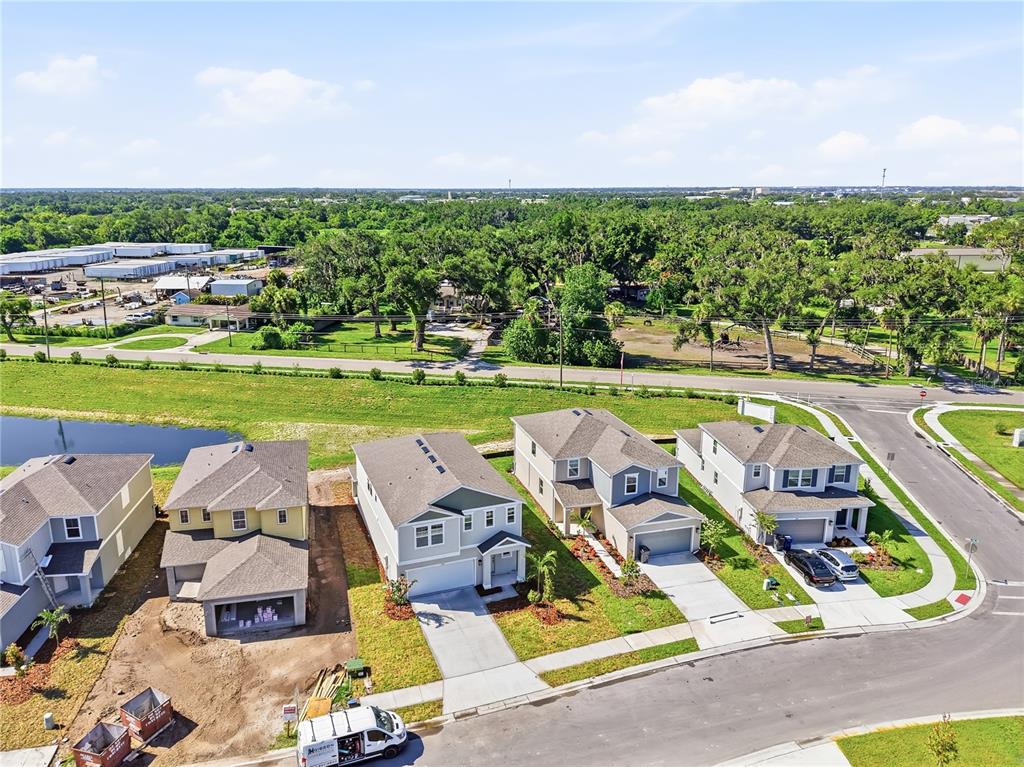 An aerial view shows a row of suburban houses near a pond and wooded area — 2513 29TH LANE E, PALMETTO, FL