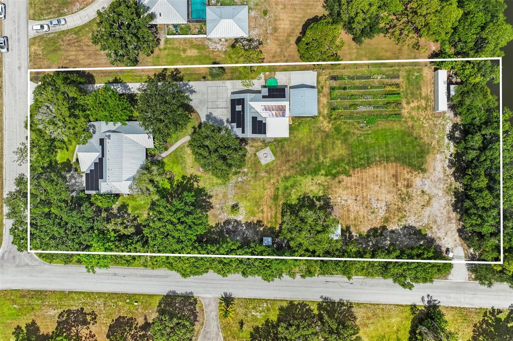 An aerial view shows two houses on a large lot with a garden and trees — 7565 CASTLE DRIVE, SARASOTA, FL