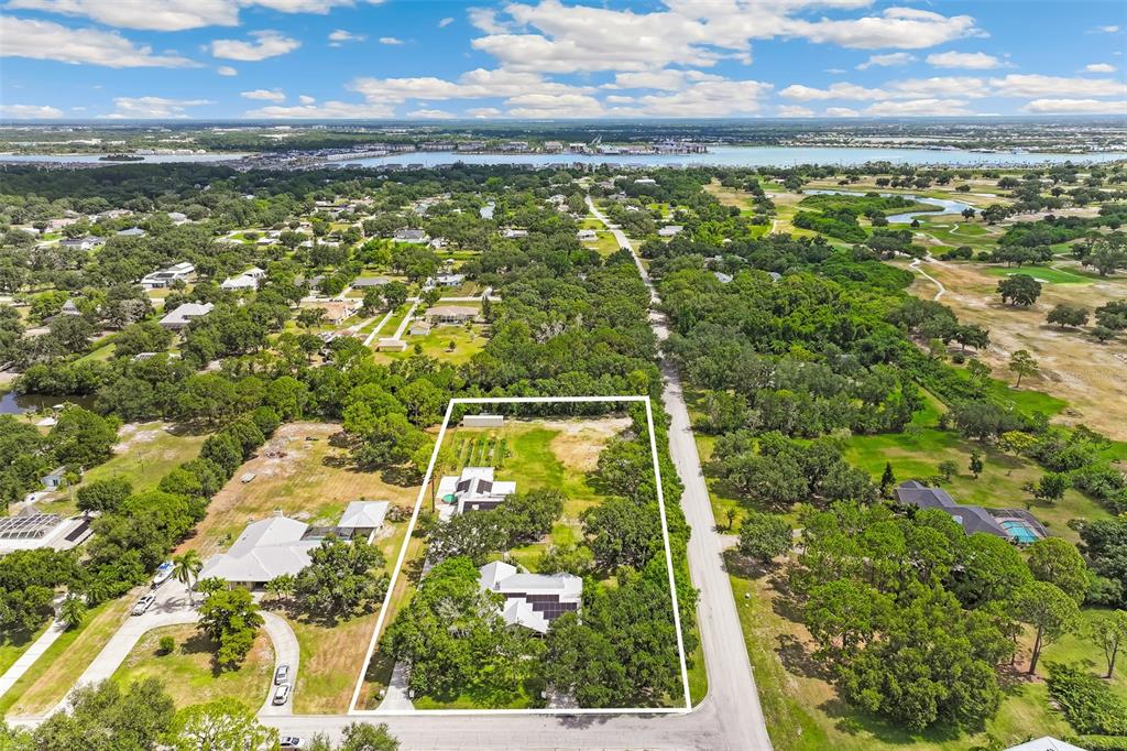 An aerial view shows a residential property outlined in white, situated near a body of water — 7565 CASTLE DRIVE, SARASOTA, FL