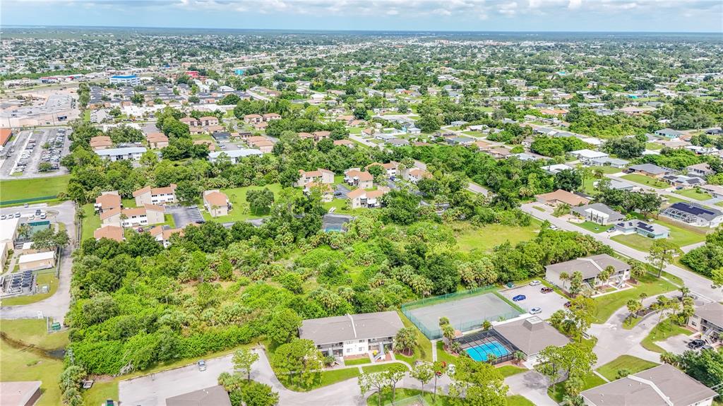 An aerial view shows a residential apartment complex with a pool and tennis court — 22501 WESTCHESTER BOULEVARD, PUNTA GORDA, FL