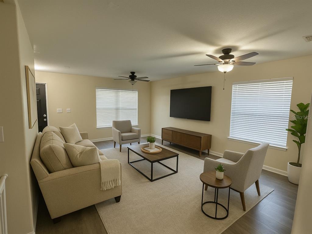 A living room features a beige sofa, two armchairs, a coffee table, and a wall-mounted television — 2924 BOATING BOULEVARD, KISSIMMEE, FL
