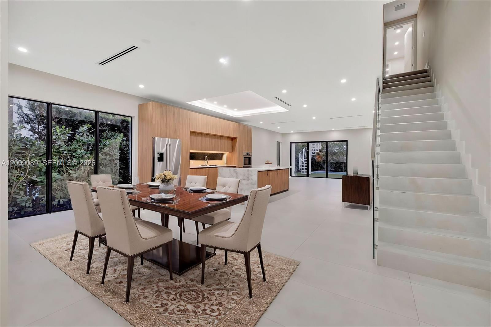 A modern open-concept dining area and kitchen feature light wood cabinetry, marble accents, and stairs — 1223 SW 12th Ct # 1223, Miami FL 33135, MIAMI, FL