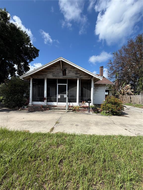 A single-story house with a screened front porch, white columns, and a concrete driveway — 512 E HICKORY STREET, ARCADIA, FL