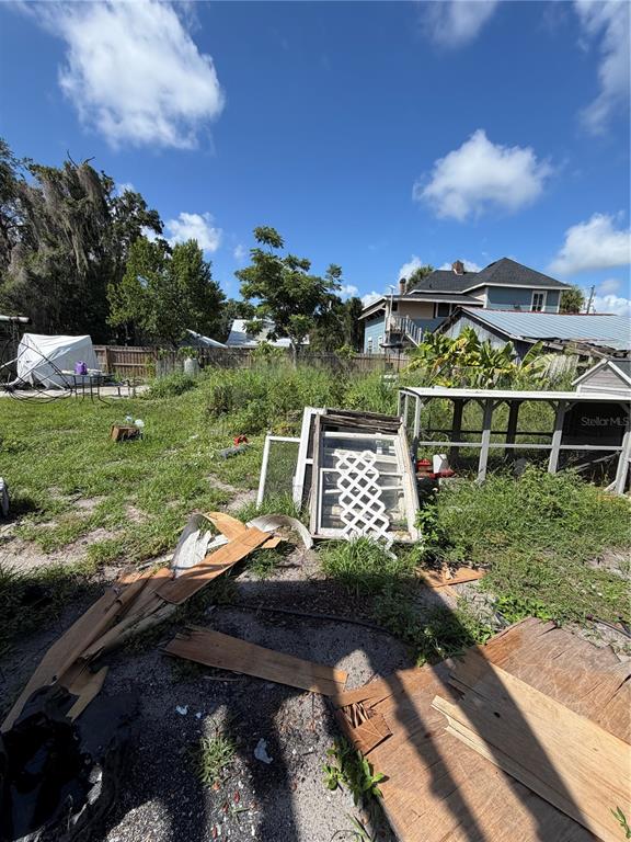 An outdoor area features scattered wooden debris, a discarded window frame, and a metal structure — 512 E HICKORY STREET, ARCADIA, FL