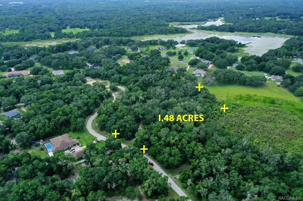 An aerial view shows a wooded 1.48-acre lot marked by yellow plus signs — 4230 S KENVERA LOOP, INVERNESS, FL