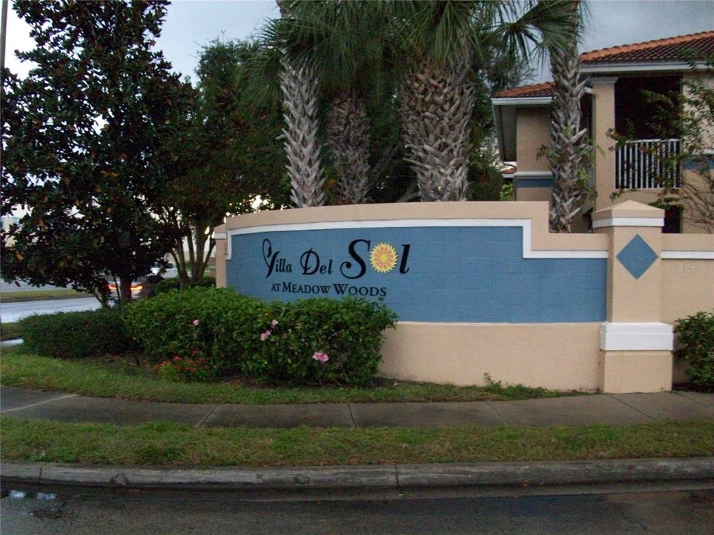 A blue and beige monument sign for Villa Del Sol at Meadow Woods — 495 LAS CORTES LANE UNIT 105, ORLANDO, FL
