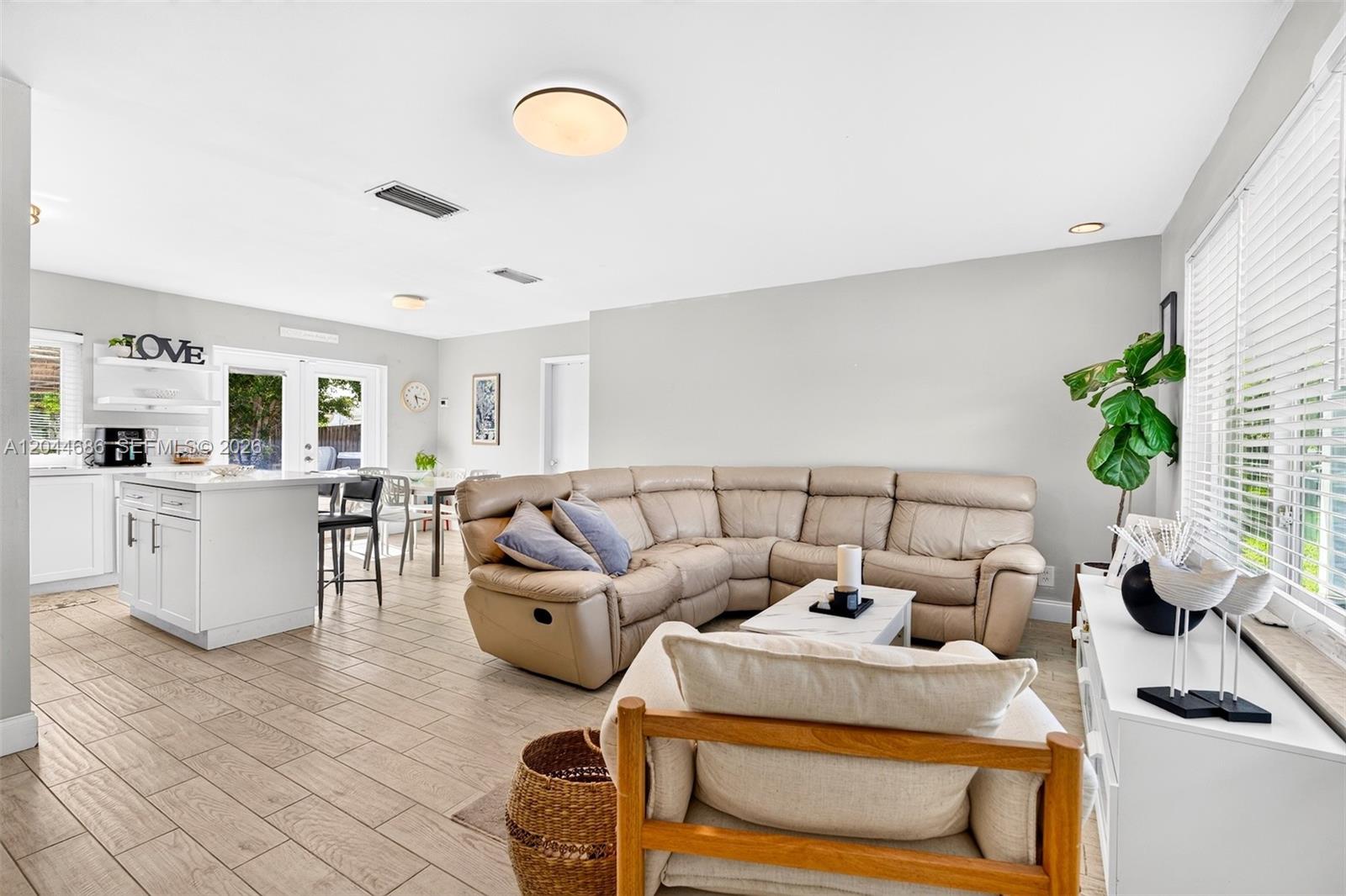 A living room with a beige sectional sofa, a white kitchen island, and tile flooring — 2012 N 31st Rd, Hollywood FL 33021, HOLLYWOOD, FL