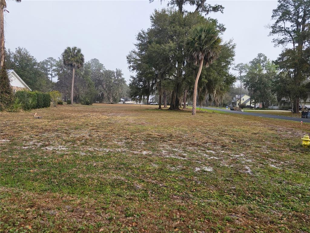 A community entrance sign stands near a pond with a fountain on a sunny day — 000 MOUNT ROYAL AVENUE, CRESCENT CITY, FL