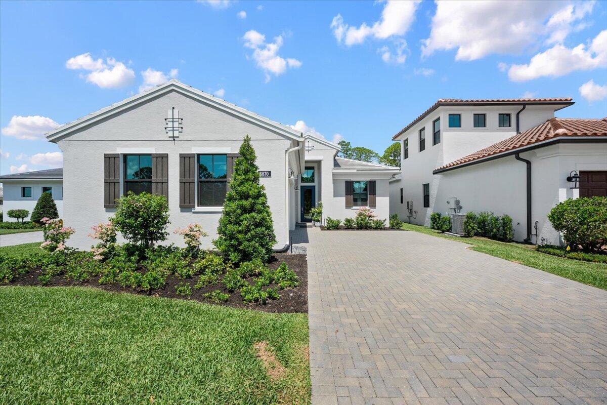 A white single-story house with a paved driveway and a two-story section on the right — 6870 SE Haven Lane, Stuart FL 34997, STUART, FL