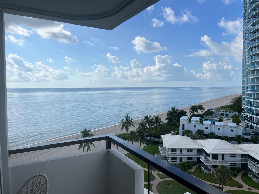 A balcony view overlooking a sandy beach, the ocean, and nearby coastal buildings — 1500 S Ocean Boulevard # 907, Pompano Beach FL 33062, POMPANO BEACH, FL