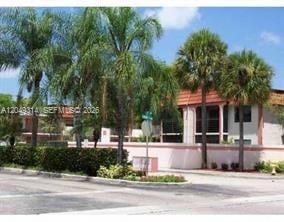 A multi-story residential building with palm trees and a low wall in the foreground — 861 NE 207th Ln # 14, Miami FL 33179, MIAMI, FL