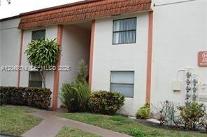 A two-story residential building with a brown tiled roof and white stucco exterior walls — 861 NE 207th Ln # 14, Miami FL 33179, MIAMI, FL