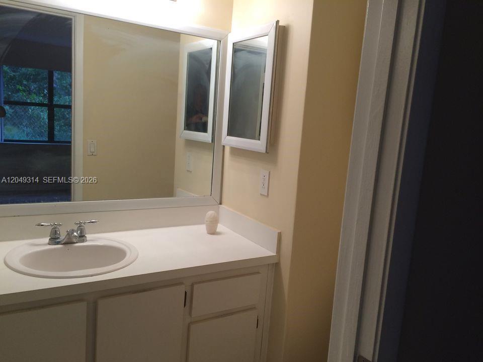 A bathroom features a white vanity with a sink, a mirror, and a medicine cabinet — 861 NE 207th Ln # 14, Miami FL 33179, MIAMI, FL
