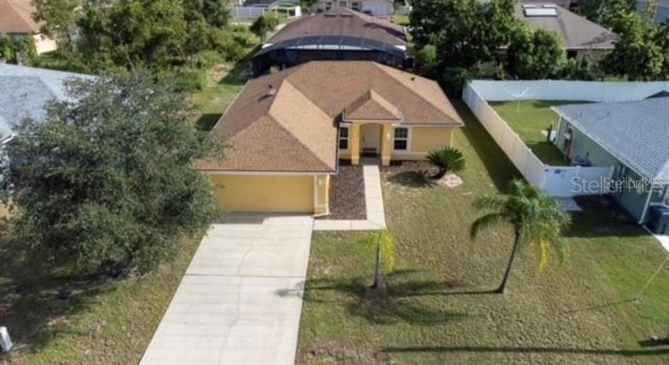 An aerial view shows a single-story yellow house with a brown roof and concrete driveway — 538 LAKEVIEW COURT, KISSIMMEE, FL