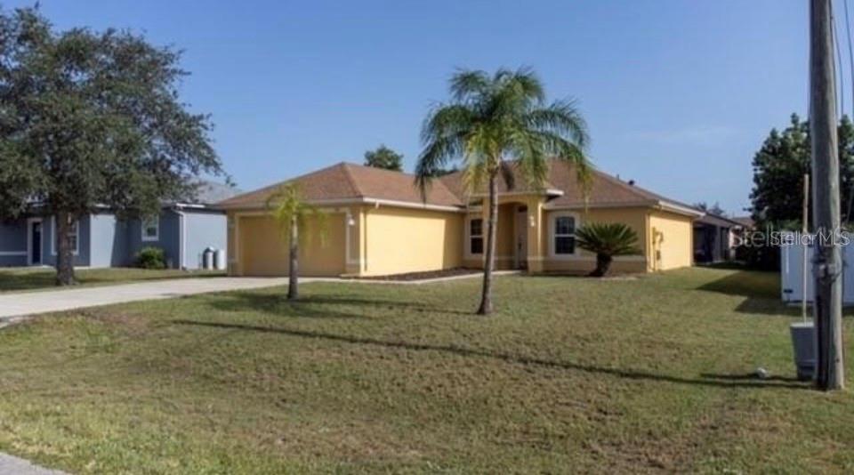 A single-story yellow house with a two-car garage and a palm tree in the yard — 538 LAKEVIEW COURT, KISSIMMEE, FL