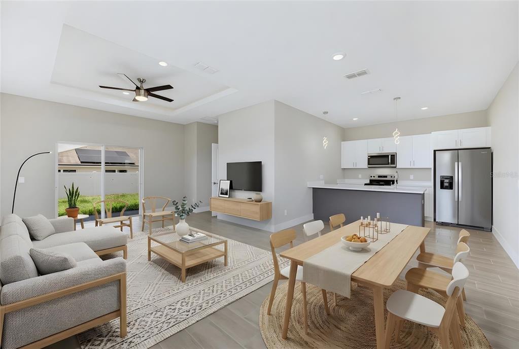 An open-concept living and dining area features a modern kitchen, light wood furniture, and tile — 804 COLVILLE DRIVE, KISSIMMEE, FL