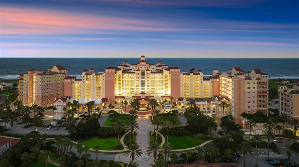 An aerial view of a large, multi-story resort hotel with palm trees and ocean views — 200 OCEAN CREST DRIVE UNIT 312, PALM COAST, FL