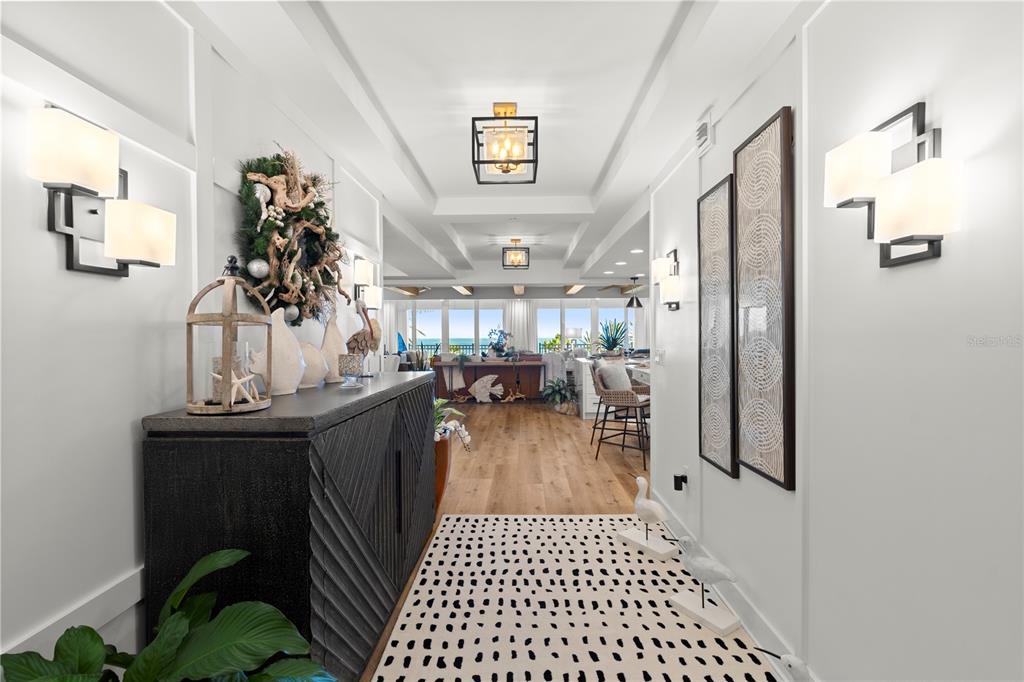 A bright hallway with white paneled walls leads to an open living area with ocean views — 200 OCEAN CREST DRIVE UNIT 312, PALM COAST, FL