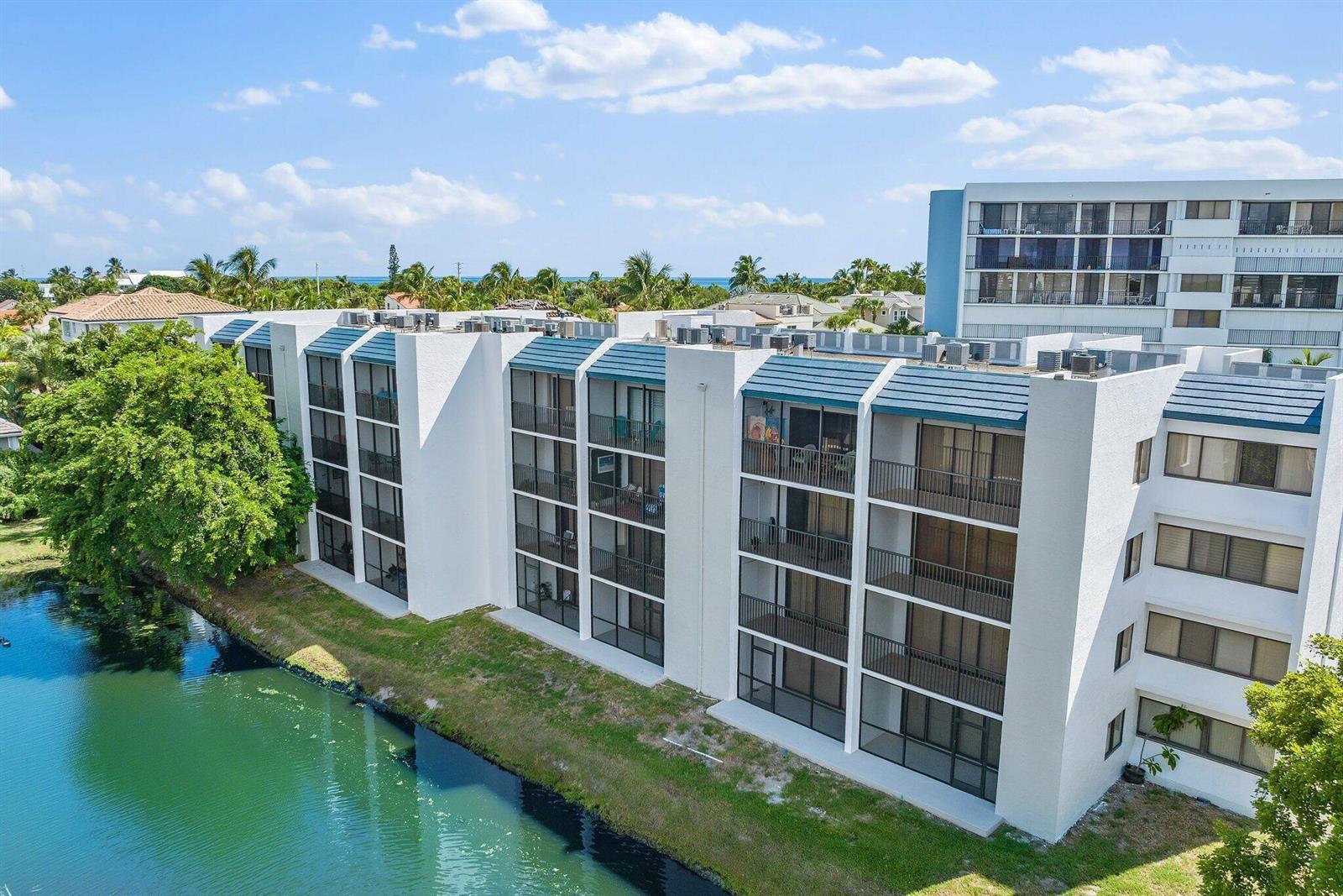 An aerial view of a multi-story white apartment building situated next to a canal — 1605 S Us Hwy 1 # A306, Jupiter FL 33477, JUPITER, FL