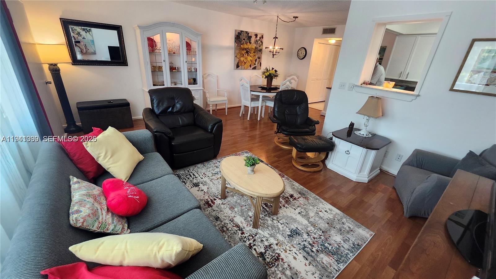 A living room features a gray sofa, two black leather chairs, and a dining area — 2112 Newport U # 2112, Deerfield Beach FL 33442, DEERFIELD BEACH, FL