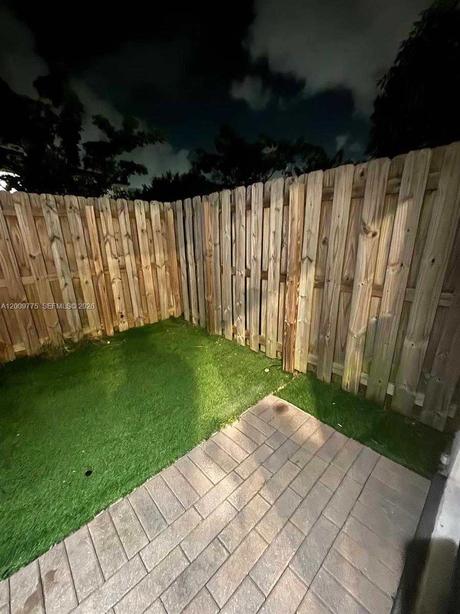 A small backyard features artificial turf, a paver patio, and a wooden privacy fence — 20964 NE 8th Ave, Miami FL 33179, MIAMI, FL