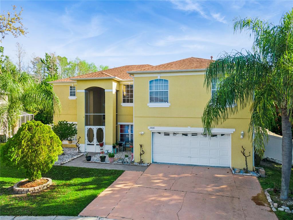 A kitchen features oak cabinets, granite countertops, a mosaic tile backsplash, and stainless steel appliances — 2606 ROYAL FERN PLACE, KISSIMMEE, FL