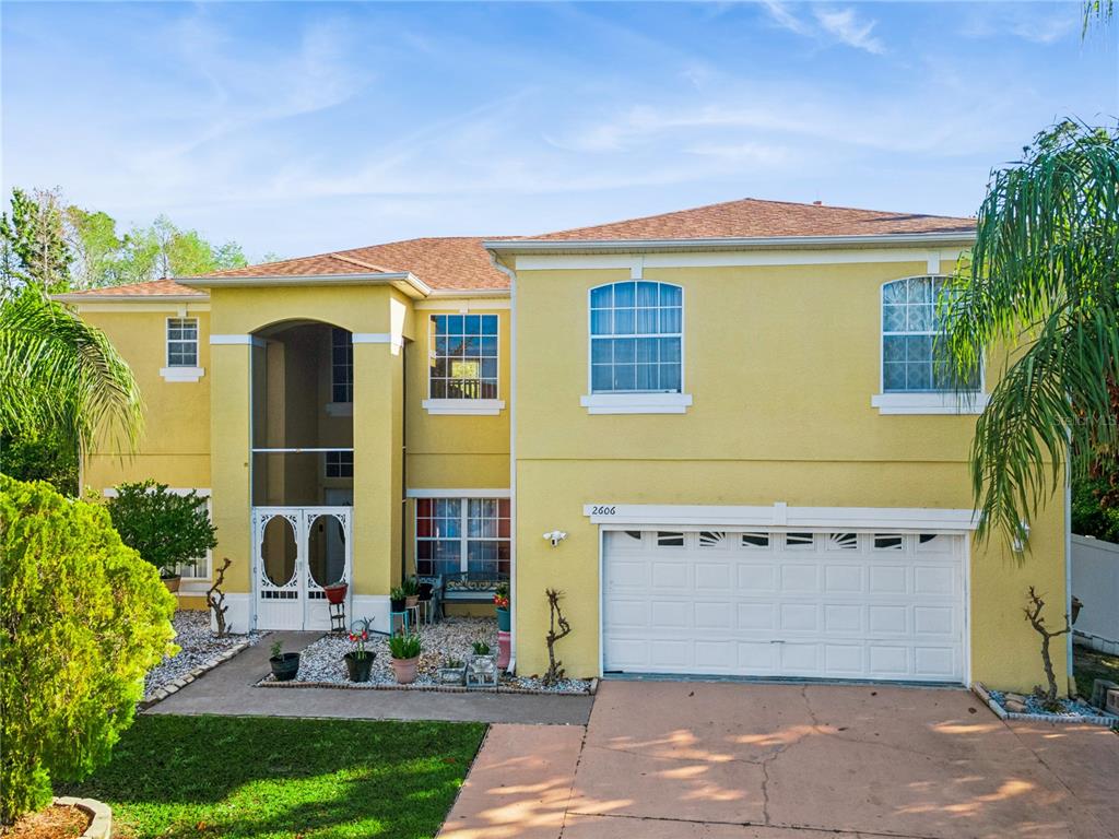 A bedroom features dark wood flooring, a ceiling fan, a dresser, and a bed — 2606 ROYAL FERN PLACE, KISSIMMEE, FL
