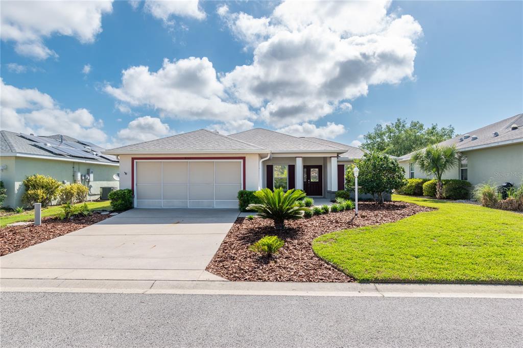 A single-story house with a two-car garage, a concrete driveway, and a landscaped front yard — 8141 SW 80TH TERRACE, OCALA, FL