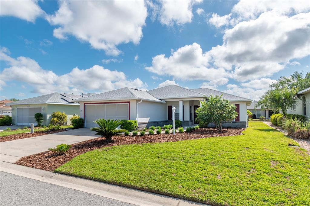 A single-story suburban house with a two-car garage, light-colored siding, and a landscaped lawn — 8141 SW 80TH TERRACE, OCALA, FL