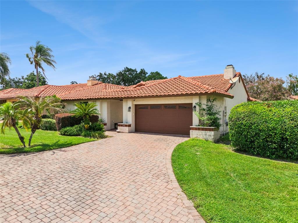 A single-story house with a terracotta tile roof and a brick-paved driveway — 7808 THE ESPLANADE COURT, ORLANDO, FL