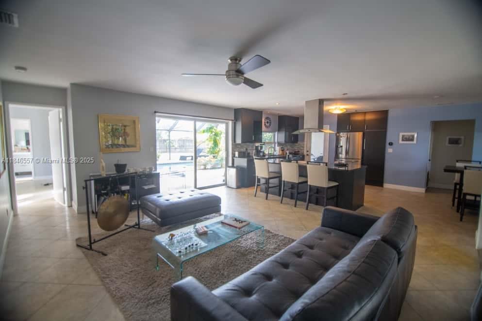 An open-concept living room and kitchen feature tile floors, a ceiling fan, and sliding doors — 4116 Taft St, Hollywood FL 33021, HOLLYWOOD, FL