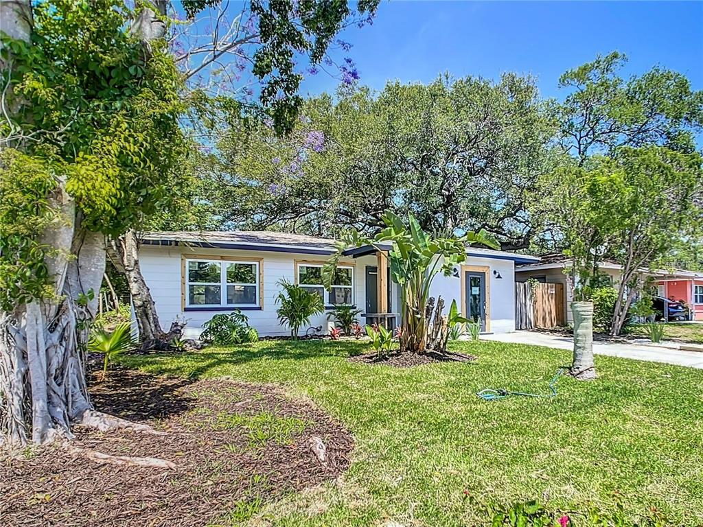 A white single-story house with a front lawn, mature trees, and a paved driveway — 4629 26TH AVENUE S, ST PETERSBURG, FL