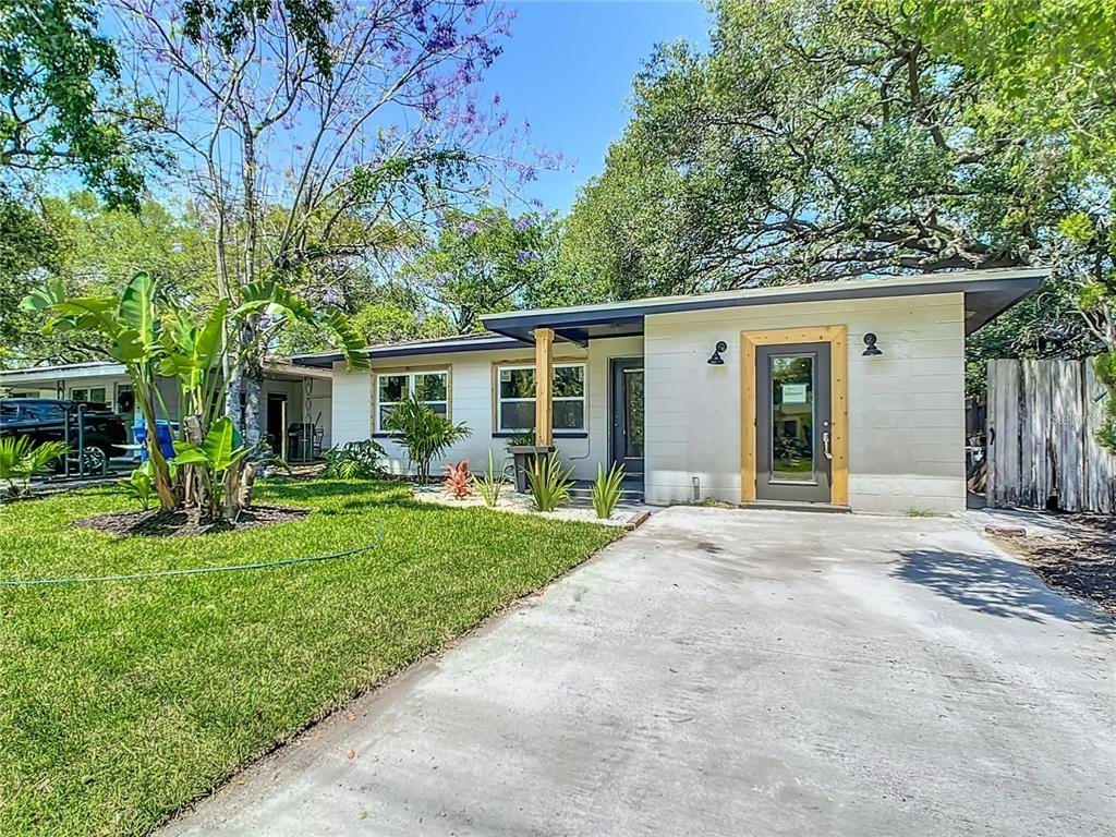 A single-story house with a concrete driveway, light-colored siding, and a wood-framed front door — 4629 26TH AVENUE S, ST PETERSBURG, FL