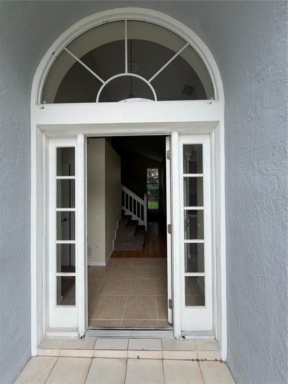 An open front door reveals a tiled entryway with a staircase leading to the second floor — 3419 SANTA MONICA DRIVE, ORLANDO, FL