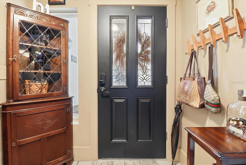 An entryway features a black front door, a wooden hutch, and a wall-mounted coat rack — 1637 SE PARADISE CIRCLE UNIT 204, CRYSTAL RIVER, FL