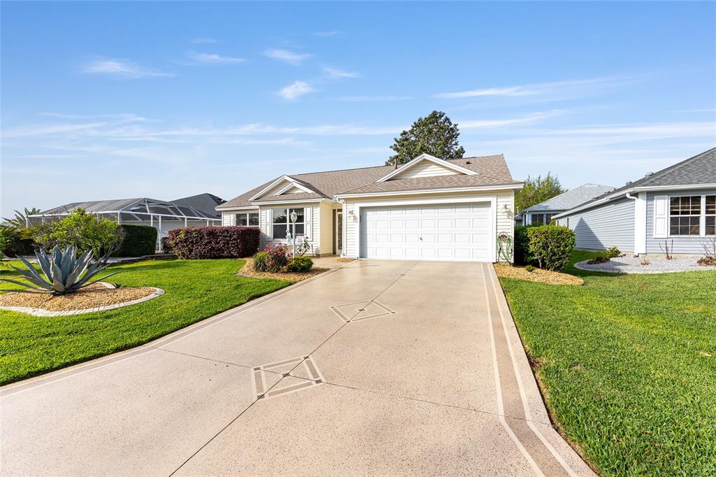 A single-story house with a two-car garage and a decorative concrete driveway — 8288 SE 176TH LAWSON LOOP, THE VILLAGES, FL