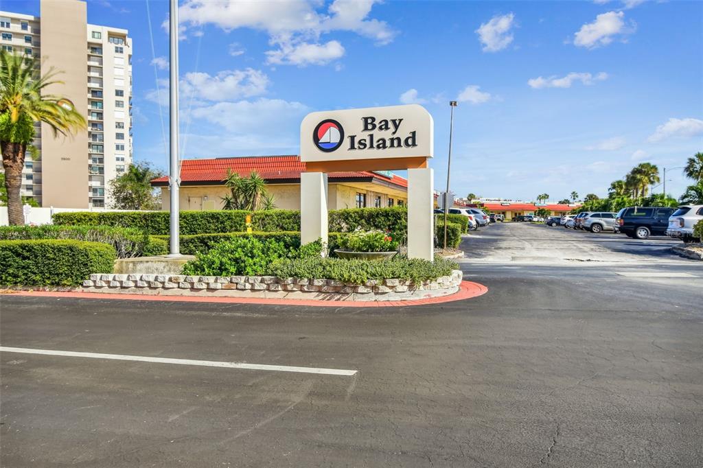 A sign for Bay Island stands at the entrance to a parking lot with buildings — 7400 SUN ISLAND DRIVE S UNIT 411, SOUTH PASADENA, FL
