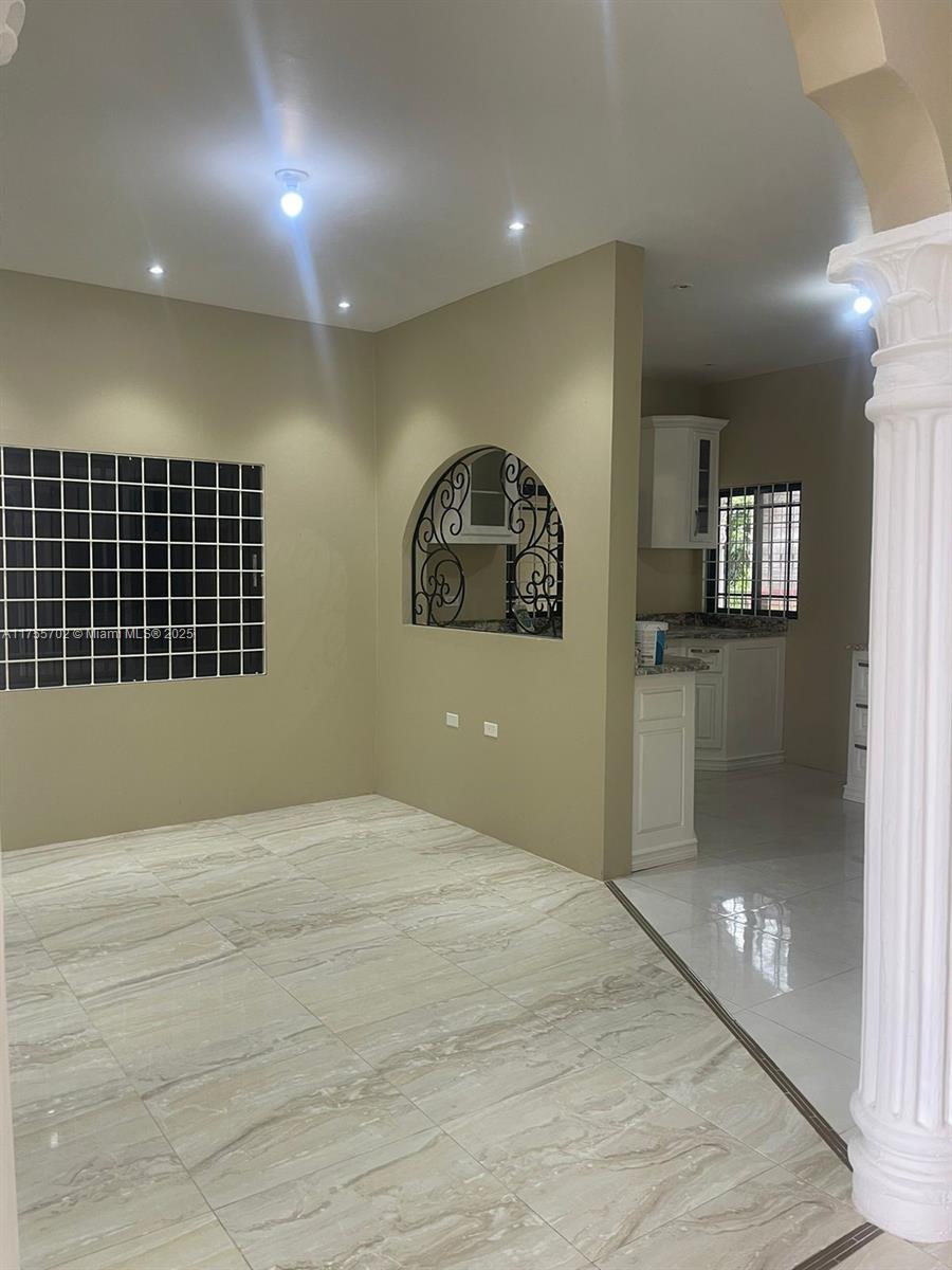 An interior view shows a tiled living area with an arched cutout looking into a kitchen — 00 Discovery Pointe, Discovery Bay, St Ann, Jamaica, NA, NA