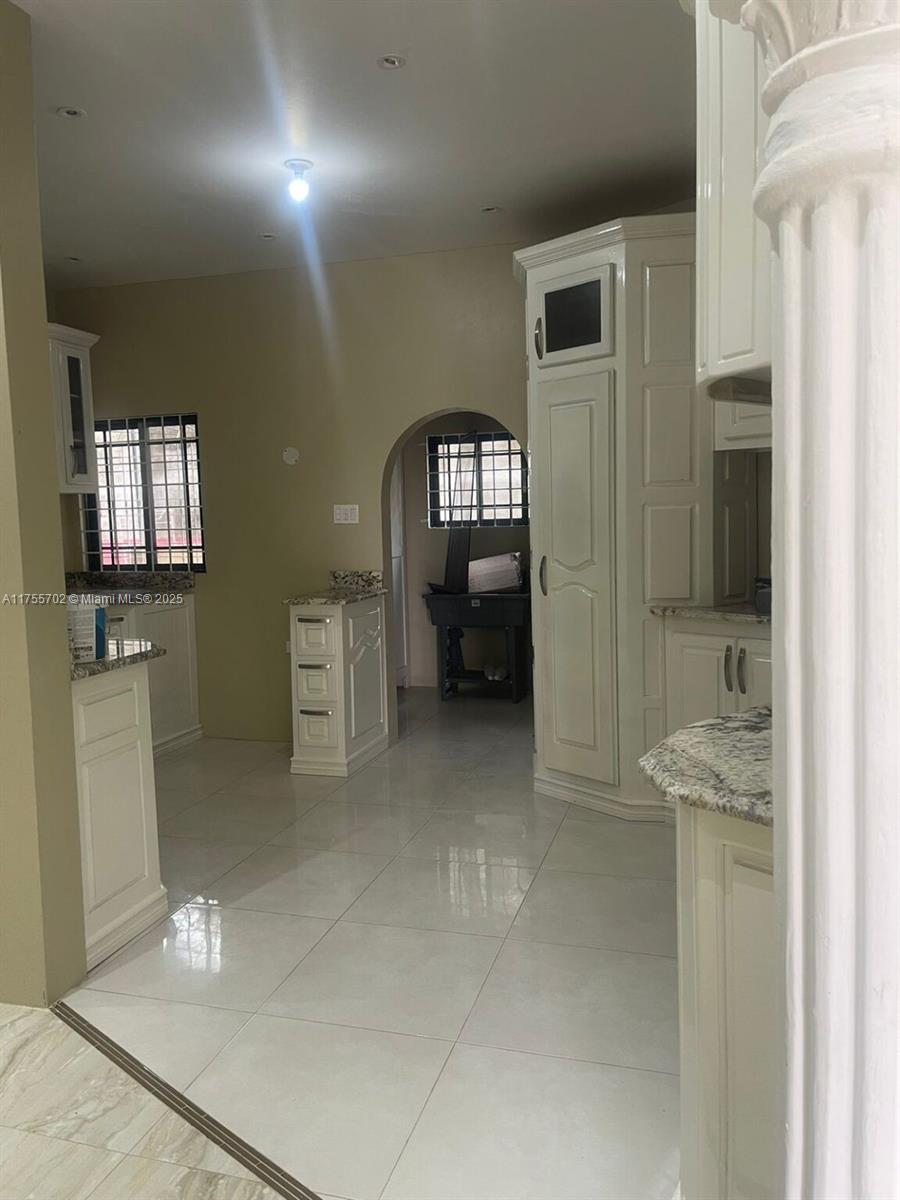 A kitchen features white cabinetry, granite countertops, and light-colored tile flooring — 00 Discovery Pointe, Discovery Bay, St Ann, Jamaica, NA, NA