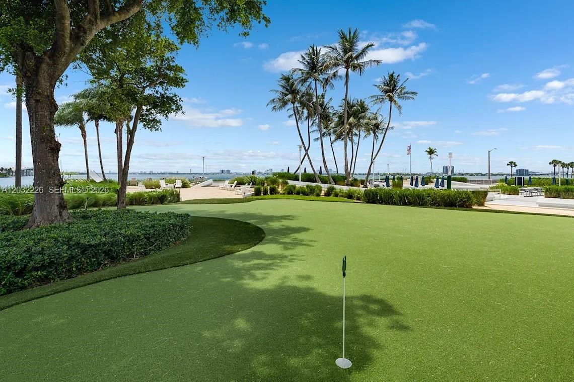 A putting green with a flagstick overlooks a sandy beach and the ocean — 555 NE 34th St # 2409, Miami FL 33137, MIAMI, FL
