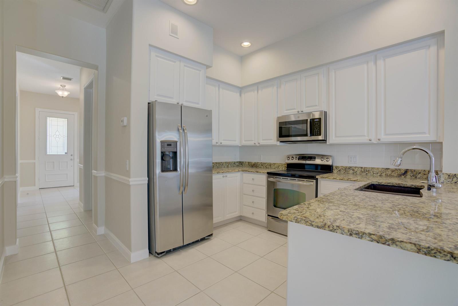 A kitchen with white cabinets, stainless steel appliances, and granite countertops — 256 San Remo Drive, Jupiter FL 33458, JUPITER, FL