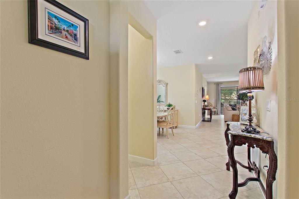 A hallway with tile flooring leads to a dining area and a living room — 1311 GLENEAGLES LANE, DAVENPORT, FL