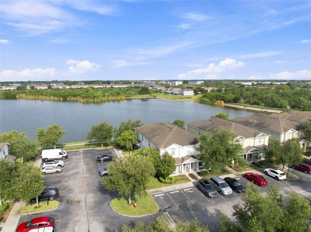 An aerial view shows a multi-family residential building with a parking lot and a lake — 4755 SOMERSET HILL LANE, RIVERVIEW, FL